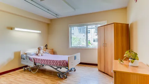 Suite bedroom with an adjustable bed and wooden wardrobe.
