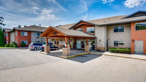 Residence exterior with a timber-framed covered entrance and parking area.