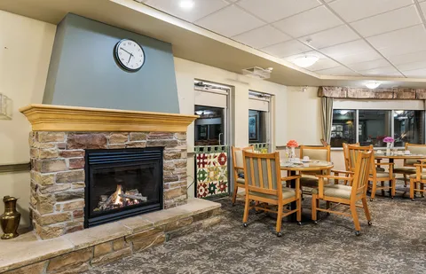 Dining tables and chairs beside a stone fireplace