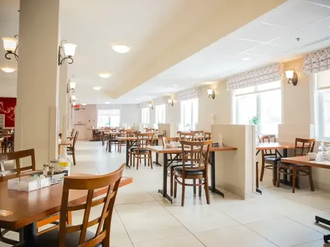 Dining room with wooden tables and chairs.