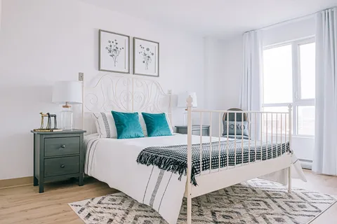 Bedroom with a white bed frame and bedside cabinets.