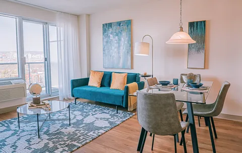 Furnished living and dining area beside a balcony.