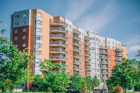 Apartment building with balconies and trees.