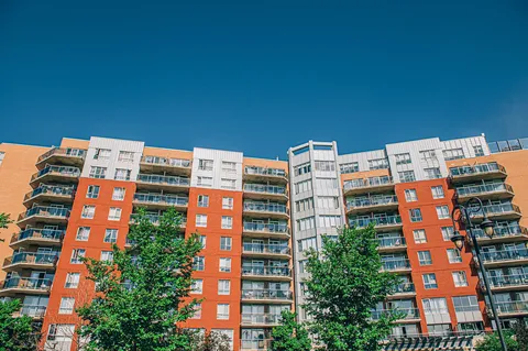 Front of the apartment building beneath a blue sky.