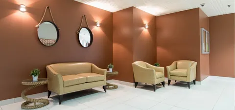 Seating area with a sofa, chairs and two round wall mirrors