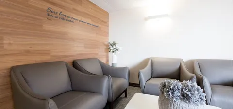 Grey armchairs around a low table beside a wooden feature wall