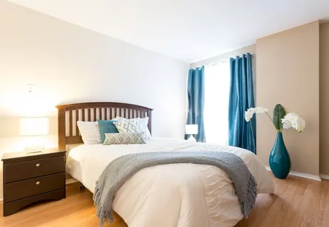 Bedroom with a wooden bed, bedside cabinet and blue curtains