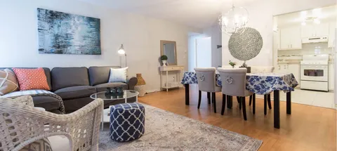 Sitting and dining area beside a white kitchen