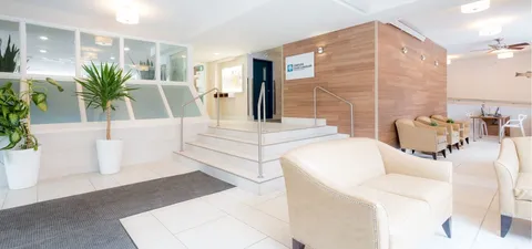 Bright sitting area beside steps, glass partitions and potted plants