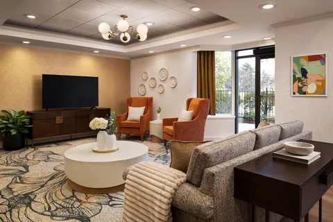 Lounge with armchairs, a sofa and a television.