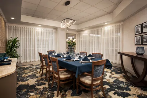 Private dining room with a set table and wooden chairs.