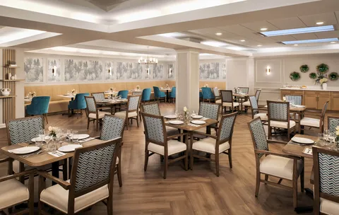 Dining room with set tables, upholstered chairs and a banquette.