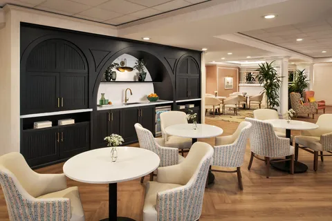 Bistro with tables, chairs and a dark cabinet counter.