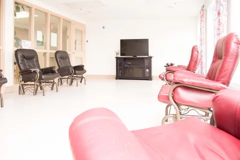Television room with red and dark cushioned armchairs