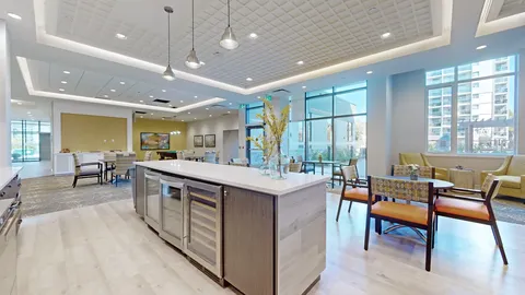 Seating beside a kitchen island, cupboards and windows