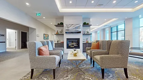 Lounge with upholstered chairs, tables, windows and a fireplace