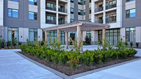 Residence buildings around a landscaped courtyard with a pergola and paths
