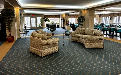 Lounge with a patterned sofa, armchairs, a globe and plants