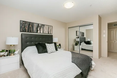 Bedroom with a double bed, mirrored wardrobe and bedside lamps
