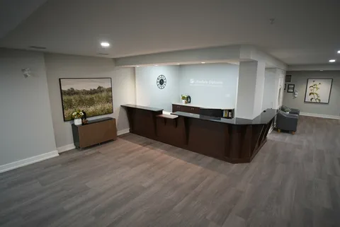 Reception counter beside a cabinet and framed landscape art