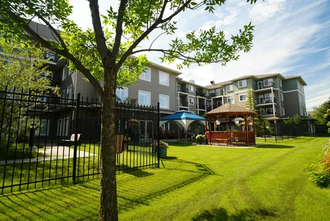 Grassy courtyard with trees, a gazebo and surrounding balconies