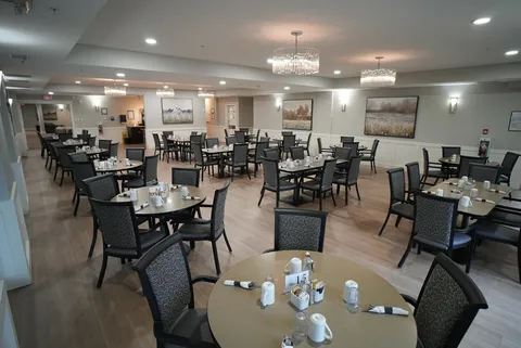 Dining room with set tables, dark chairs and wall art
