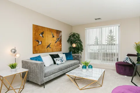 Sitting area with a sofa, white coffee table and large windows