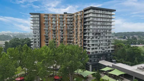 Aerial view of a residence building with balconies and shaded terraces.