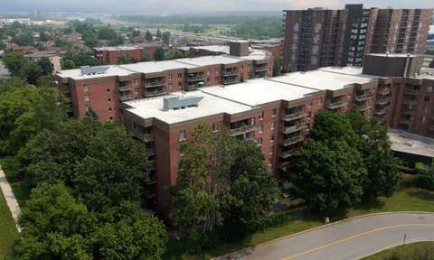 Aerial view of lower residence buildings surrounded by trees.