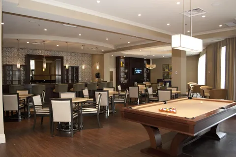 Pub lounge with a billiard table, dining tables and a bar.