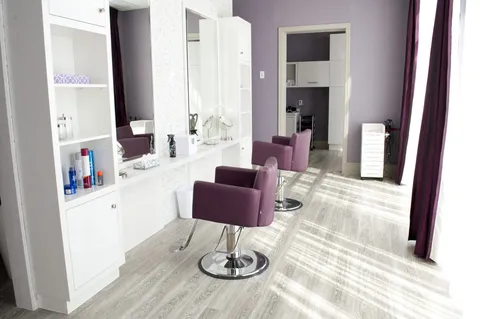 Hair salon with styling chairs, mirrors and washbasins.