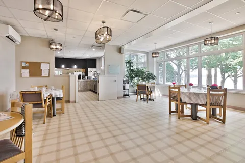Dining area with round tables, wooden chairs and large windows
