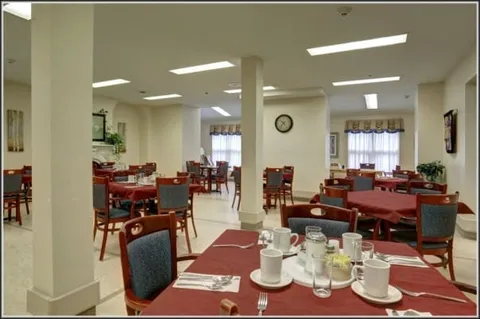 Dining room with set tables, chairs and white columns.