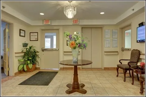 Entrance foyer with glass doors, a round table and chandelier.