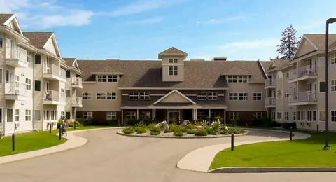 Residence exterior around a curved driveway with lawns and planted beds.