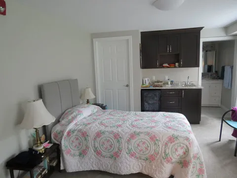 Bedroom with a patterned quilt and kitchenette