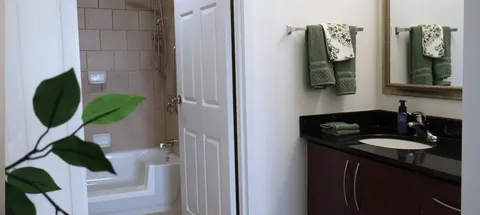 Bathroom with a vanity, mirror and bathtub.