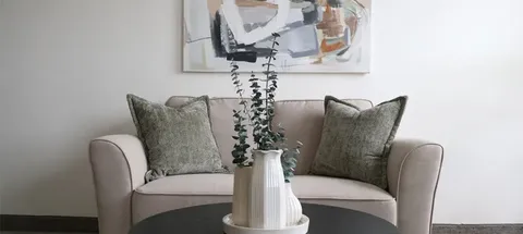 Sofa with cushions and a coffee table in a studio suite.