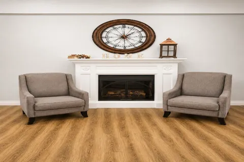 Sitting area with two armchairs, a fireplace and a wall clock.