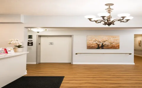 Entrance lobby with an elevator, reception counter and chandelier.