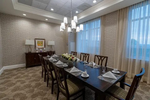 Set dining table with wooden chairs beneath a chandelier