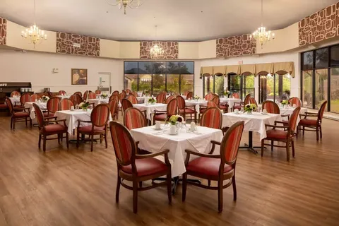 Dining room with set tables, red chairs and chandeliers