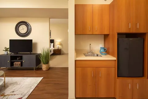Kitchenette beside a sitting area with a television