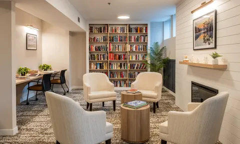 Library lounge with armchairs and bookshelves