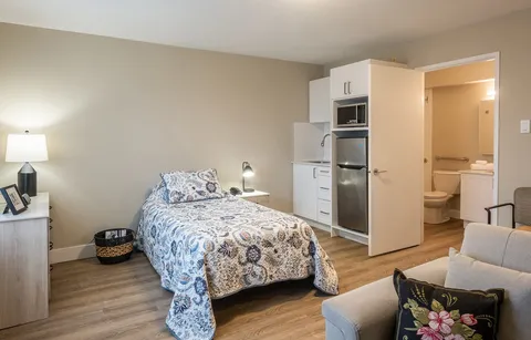 Studio suite with bed, kitchenette and armchair