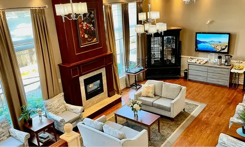 Lounge with fireplace, sofas and tall windows
