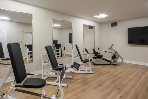 Fitness room with exercise machines and mirrored wall