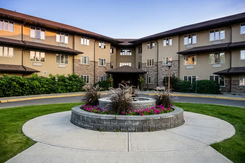 Residence exterior and entrance beyond a circular planted garden bed
