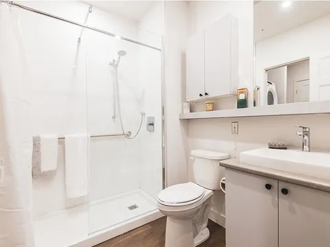 Bathroom with a glass shower, toilet, sink and mirror