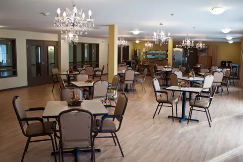 Dining room with tables, chairs and chandeliers.